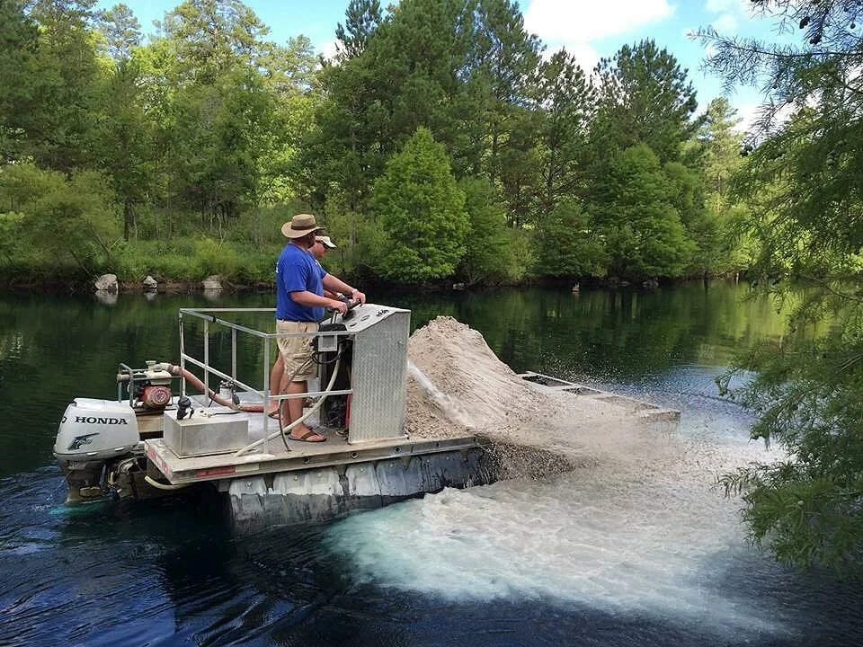 Material being delivered to a pond by work boat